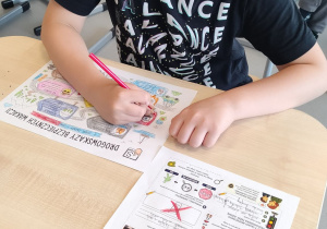 uczeń koloruje kartę pracy „Drogowskazy bezpiecznych wakacji”