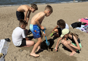 Uczniowie budują zamek z piasku