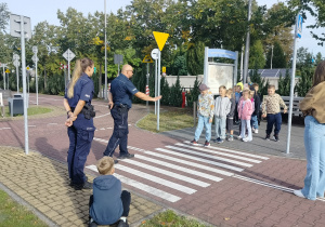 policjanci tłumaczą, jak bezpiecznie przechodzić przez przejście dla pieszych
