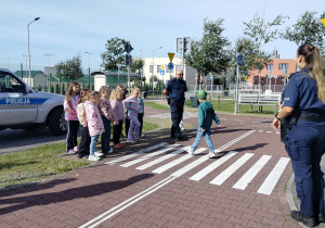 chłopiec prezentuje jak bezpiecznie przechodzić przez przejście dla pieszych