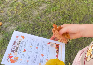Uczennica prezentuję swoją kartę „Jesiennego detektywa”