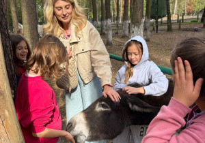 pani i dziewczynki karmią osiołka