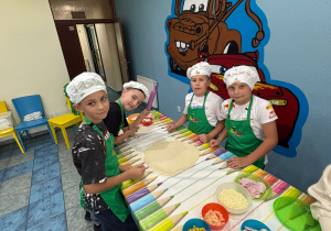chłopcy wyrabiają ciasto na pizzę