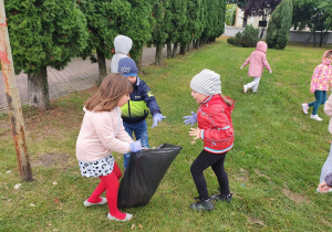 Grupa dzieci trzymająca worek na śmieci.