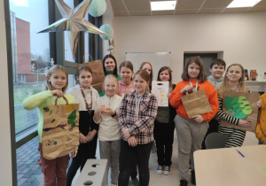 Uczniowie klas IV dumnie prezentują swoje prace.