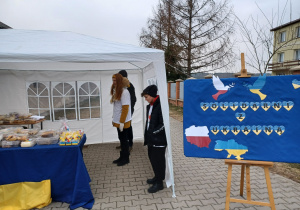 Troje uczniów oraz napis "Solidarni z Ukrainą"