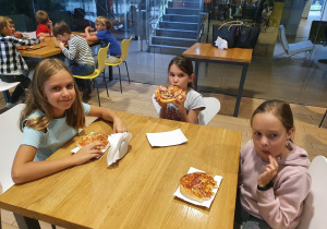 dziewczynki jedzą pizzę