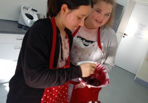 uczennice dekorują tort szwarcwaldzki