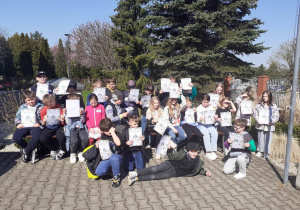 Uczniowie prezentują Certyfikaty Przyjaciela Ziemi.