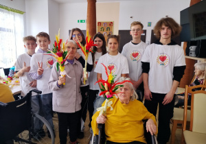 Wolontariusze z seniorami prezentują wykonane palmy wielkanocne