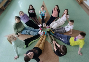 uczniowie siedząc w kole prezentują kolorowe skarpety