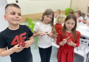 Czerwony czwartek - uczniowie prezentują udekorowane galaretki z czerwonymi owocami.