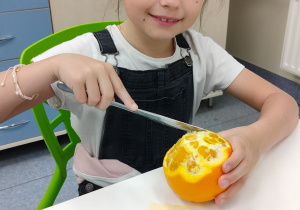 dziewczynka obiera pomarańcze na sok