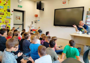 uczniowie zadają pytania policjantowi